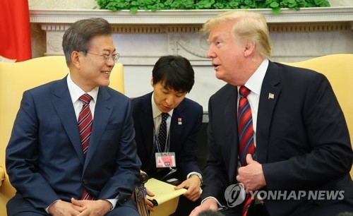 In the photo, taken May 22, 2018 (U.S. time), South Korean President Moon Jae-in (L) and U.S. President Donald Trump are seen talking to each other in a bilateral summit held at the White House. (Yonhap)