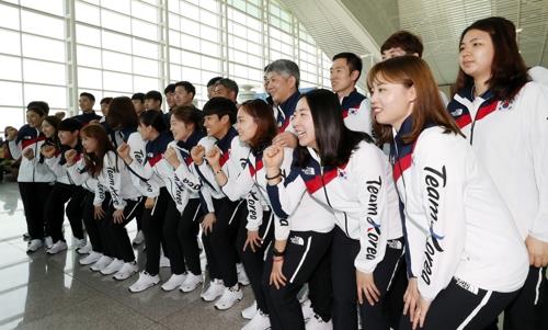 Members of the South Korean men's and women's national badminton teams pose for photos at Incheon International Airport on Aug. 15, 2018, before departing for Indonesia to compete at the 18th Asian Games. (Yonhap)