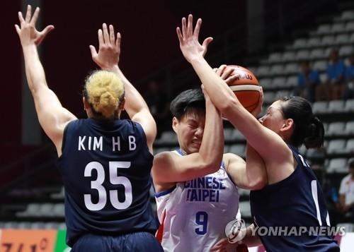 South Korean player Kim Han-byul (L) and Ro Suk-yong of North Korea (R), both on the unified Korean women's basketball team, guard Huang Pingjen of Chinese Taipei during the teams' Group X game of the Asian Games at GBK Basketball Hall in Jakarta on Aug. 17, 2018. (Yonhap)