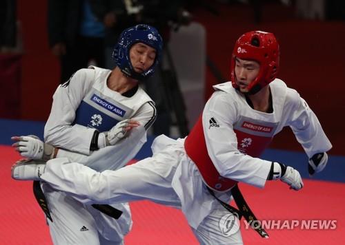 South Korea's Lee Hwa-jun (R) competes in the men's 80-kilogram division taekwondo sparring competition at the 18th Asian Games in Jakarta on Aug. 22, 2018. (Yonhap)