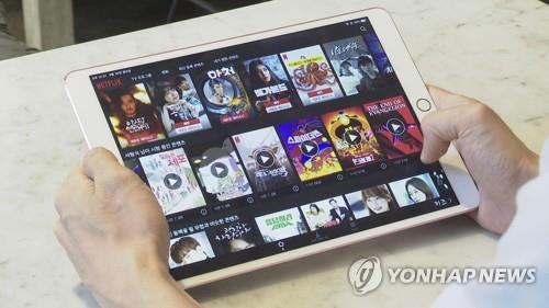 This undated image from Yonhap News TV shows a person browsing an over-the-top (OTT) platform on a tablet. (PHOTO NOT FOR SALE) (Yonhap)