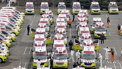 Ambulances are parked outside a water purification plant in Daegu on March 1, 2020, with emergency workers checking their vehicles. (Yonhap)