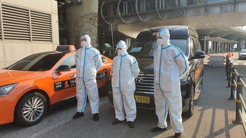 This photo, provided by the Seoul city government, shows taxi drivers in protective gear who have driven taxis exclusively for passengers from abroad at Incheon International Airport, west of Seoul, since March 31, 2020