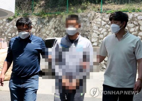 This photo, provided by the Taean Maritime Police Station in the western coastal county of Taean, shows a Chinese national (C) being taken to the police station. He is one of eight Chinese people who sneaked onto the west coast of South Korea via a 1.5-ton motorboat from China on May 21, 2020. (PHOTO NOT FOR SALE) (Yonhap)