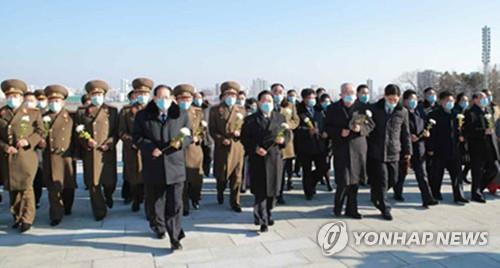 This image, captured from North Korea's Rodong Sinmun newspaper on Jan. 17, 2021, shows Choe Ryong-hae, the president of the Presidium of the Supreme People's Assembly, and parliamentary representatives walking toward statues of former North Korean leaders in Pyongyang to offer flowers. (PHOTO NOT FOR SALE) (Yonhap) 