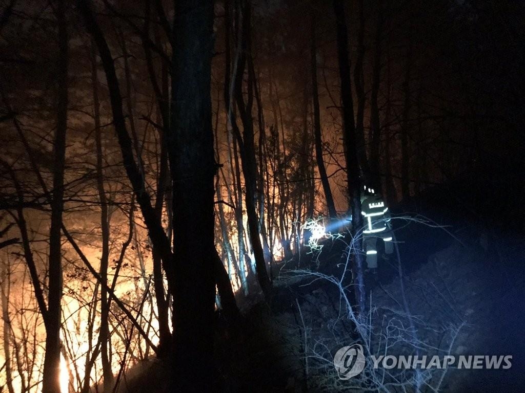 Firefighters work to contain a wildfire in Andong, North Gyeongsang Province, on Feb. 21, 2020, in this photo provided by the National Fire Agency. (PHOTO NOT FOR SALE) (Yonhap)