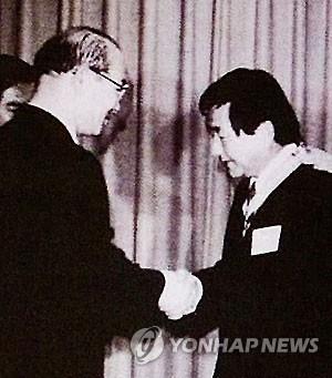 This file photo, provided by activists seeking the truth behind human rights violations at the Brothers Home, shows the facility's late owner Park In-keun shaking hands with then President Chun Doo-hwan. (Yonhap)