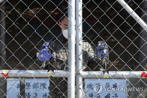 This file photo taken on Oct. 5, 2020, shows a service member closing the gate of his unit in Pocheon, Gyeonggi Province, after the unit reported multiple COVID-19 cases among its members. (Yonhap)