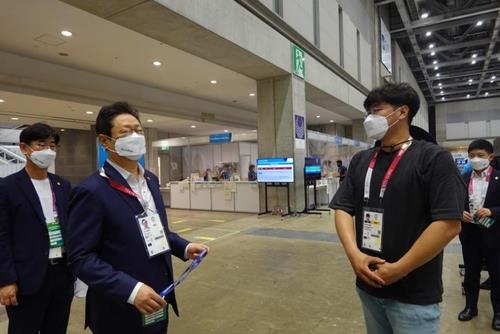 South Korean Minister of Culture, Sports and Tourism Hwang Hee (2nd from L) talks to a South Korean reporter at the Tokyo Olympics Main Press Center in Tokyo on July 24, 2021. (Yonhap)