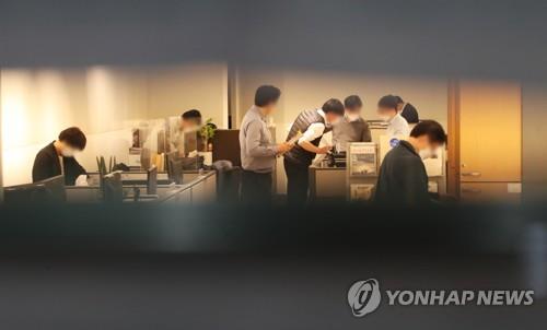 Prosecution investigators search the office of the Seongnam mayor's secretaries on Oct. 21, 2021, the entrance of which is plastered with newspaper sheets. (Yonhap)