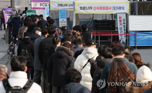 People wait in line to get tested for the coronavirus near a temporary testing center in front of Seoul Station in Seoul on March 7, 2022. (Yonhap)