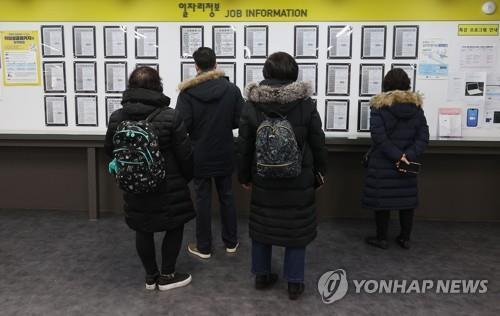 This undated file photo shows jobseekers looking at employment information at a job arrangement facility in Seoul. (Yonhap)