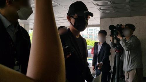 A crypto investor (C), accused of ringing the doorbell of the apartment of Do Kwon, co-founder and CEO of Terraform Labs, enters Seongdong Police Station in Seoul on May 16, 2022. (Yonhap)