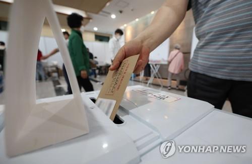 A voter casts ballots at a polling station in Seoul on May 27, 2022, the first day of two-day early voting for the June 1 local elections and parliamentary by-elections. (Yonhap)