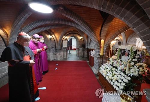 Cardinal Andrew Yeom Soo-jung (L) and Archbishop Peter Chung Soon-taick of the Seoul archdiocese (2nd from L) pay tribute to former Pope Benedict XVI at a memorial altar set up in Myeongdong Cathedral in central Seoul on Jan. 1, 2023. (Yonhap)