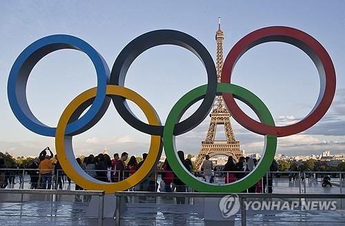 This Associated Press photo shows an Olympic emblem installation in front of the Eiffel Tower in Paris. (Yonhap)