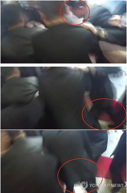 倒れた韓国人カメラマンに暴行を加える中国警護員（ＣＢＳノーカットニュース提供）＝１４日、北京（聯合ニュース）