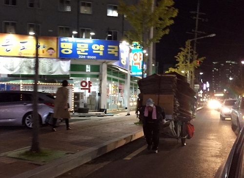 도롯가를 위태롭가 지나는 폐지수레.
