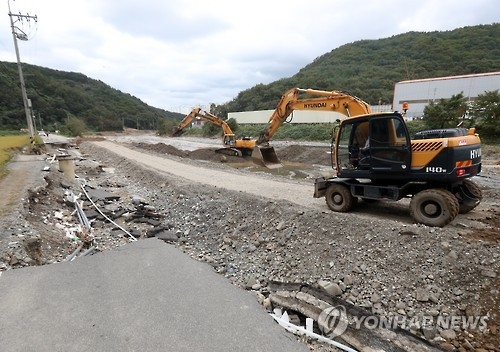 (울산=연합뉴스) 김용태 기자 = 태풍 차바가 몰고 온 폭우에 하천이 불어나면서 울산시 북구 대안마을로 향하는 진입도로가 무너졌다. 지난 10월 11일 중장비가 동원돼 도로 복구작업이 이뤄지고 있다. 2016.10.11yongtae@yna.co.kr(끝)