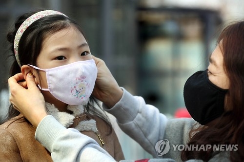 딸에게 마스크 씌워주는 어머니