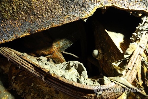 찢긴 철판 사이로 드러난 세월호 화물칸 내부. 자동차와 CCTV 카메라가 보인다.