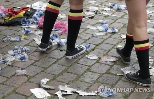 지난해 6월 벨기에 보르도에서 열린 유로 2016 경기 후 플라스틱 컵이 버려진 거리를 걷는 벨기에 팬.