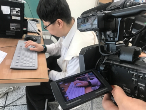 발달장애인 딸이 컴퓨터를 하는 모습을 촬영하는 어머니