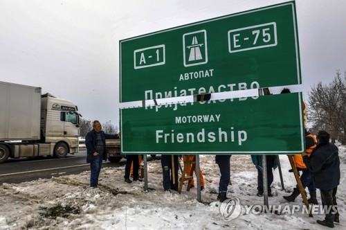 마케도니아가 국명 분쟁에 대한 의지를 보이기 위해 그리스 접경으로 이어지는 '알렉산더' 고속도로의 이름을 이달 초 우정 고속도로로 바꾼 뒤 표지판 교체 작업을 벌이고 있다. [EPA=연합뉴스] 