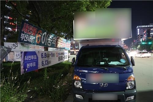 7일 밤 투표 안내 현수막 가린 유세차량