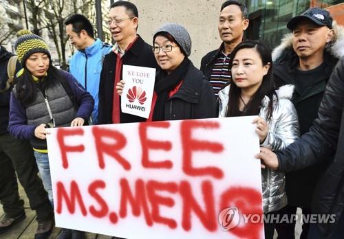 10일 멍완저우 화웨이 CFO의 보석 심리가 열린 캐나다 밴쿠버 브리티시컬럼비아 법원 앞에서 중국인들이 그의 석방을 촉구하는 팻말을 들고 있다. [AP=연합뉴스] 