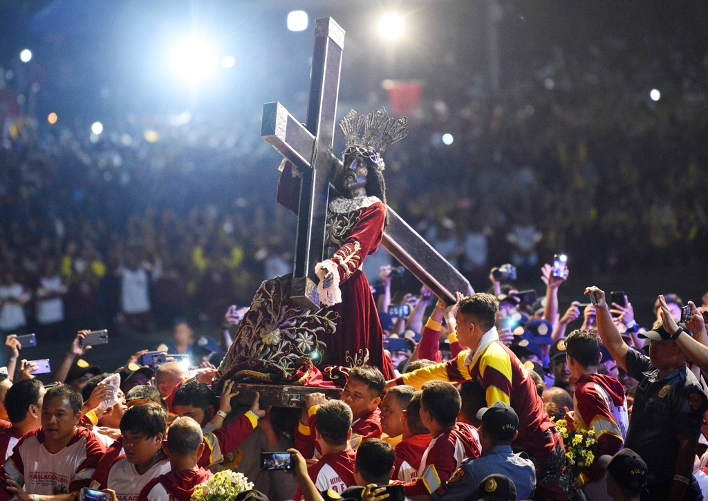 (마닐라 AFP=연합뉴스) '블랙 나자렌'(Black Nazarene) 퍼레이드에서 참가자들이 '검은 예수상'을 들고 이동하고 있다. 