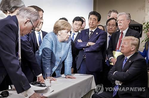 캐나다 퀘벡주 샤를부아에서 지난해 6월 9일(현지시간) 열린 주요 7개국(G7) 정상회의에서 도널드 트럼프 미국 대통령(오른쪽)이 팔짱을 낀 채 의자에 앉아 있고 앙겔라 메르켈 독일 총리(가운데 왼쪽)가 두 손으로 테이블을 누르며 트럼프 대통령을 내려다보고 있다. [AP=연합뉴스 지료사진]