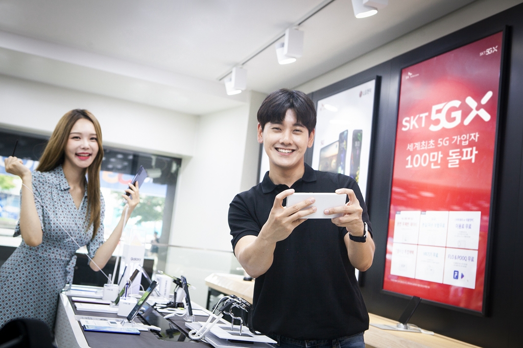 SK텔레콤 모델들이 서울 명동에 위치한 대리점에서 '갤럭시 노트10'로 5G 서비스를 사용하고 있는 모습 [SKT 제공]