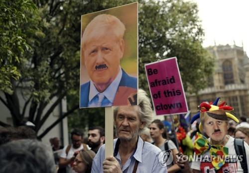 브렉시트 반대론자들이 존슨 총리를 히틀러로 묘사한 사진을 들고 행진하고 있다. [AP=연합뉴스]