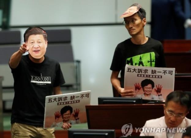 캐리람 홍콩 장관의 시정연설을 방해하는 야당 의원이 시진핑 주석의 가면을 쓰고 있다