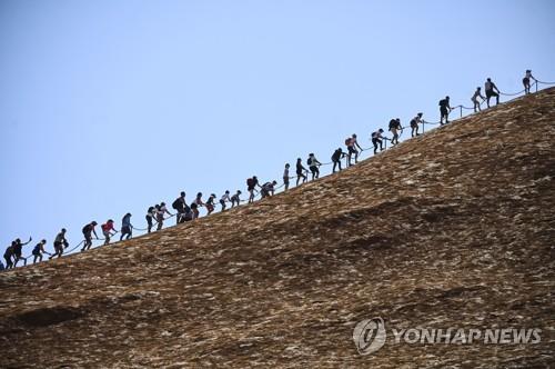울루루에 오르는 관광객들의 모습.