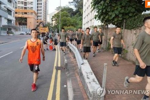 홍콩 거리에서 청소 작업을 벌이는 중국군에 포함된 대테러 특수부대원(왼쪽)