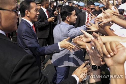 2019년 10월 20일 지지자들에게 화답하는 조코 위도도 인도네시아 대통령(왼쪽에서 두 번째)과 기브란 라카부밍 라카(가운데 회색 양복). [AP=연합뉴스]