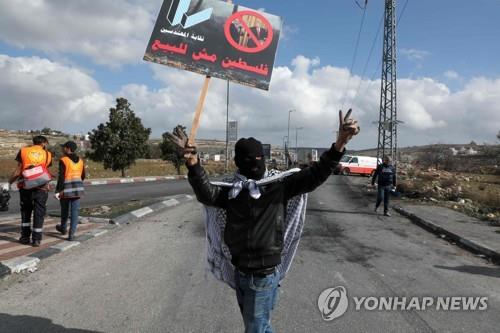 지난 1월 30일(현지시간) 요르단강 서안에서 복면을 쓴 팔레스타인인이 미국의 중동평화구상에 반대하는 시위를 하고 있다.[AFP=연합뉴스]