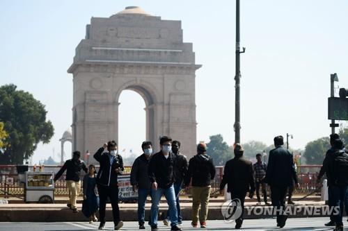 마스크를 쓰고 인도 뉴델리 시내 인디아게이트 앞을 지나는 관광객. [AFP=연합뉴스]