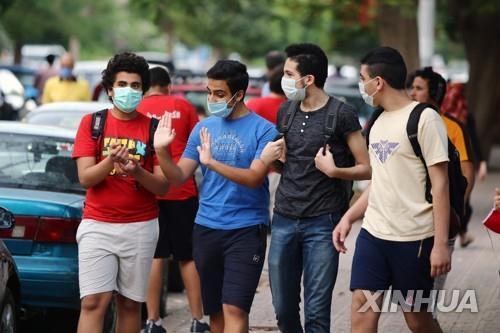 6월 12일(현지시간) 이집트 수도 카이로의 한 거리에서 마스크를 쓴 젊은이들이 걷고 있다.[신화=연합뉴스]