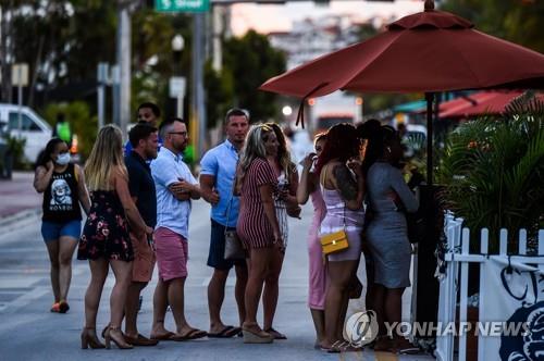 26일(현지시간) 미국 플로리다주 마이애미비치의 한 식당 앞에 입장하려는 사람들이 바짝 붙어선 채 줄 서 있다. [AFP=연합뉴스]