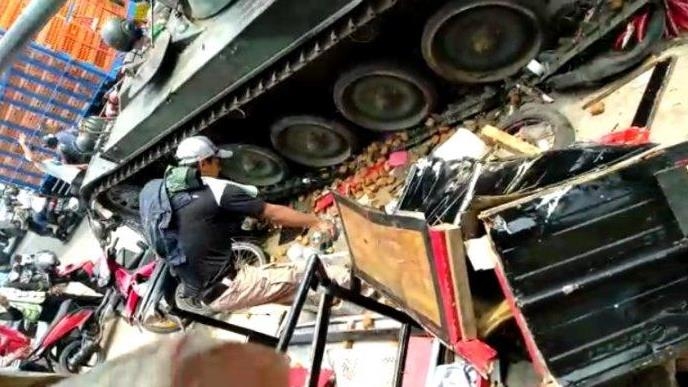 인도네시아 육군 탱크와 충돌해 부서진 노점과 오토바이들 