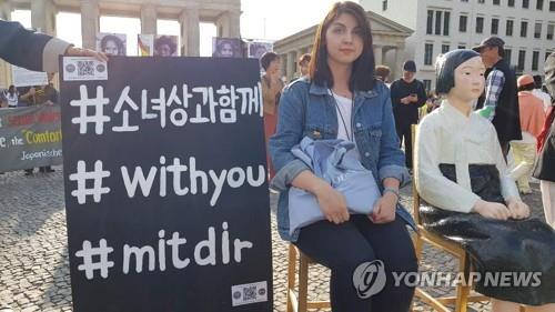 베를린에서 소녀상과 함께 사진을 찍는 시민