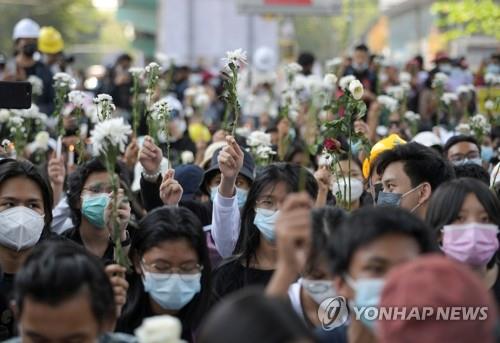 (양곤 로이터=연합뉴스) 미얀마 최대 도시인 양곤에서 24일 군부 쿠데타 규탄 시위대가 꽃을 들고 시위를 벌이고 있다. 미얀마에서는 지난 1일 쿠데타가 발발한 이후 연일 항의 시위가 이어지고 있다. sungok@yna.co.kr