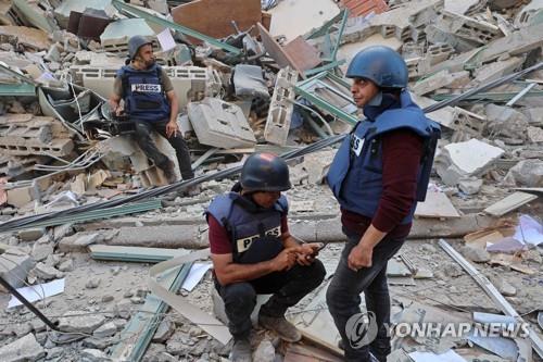 이스라엘군의 폭격으로 무너진 건물 잔해에 주저 앉은 취재진