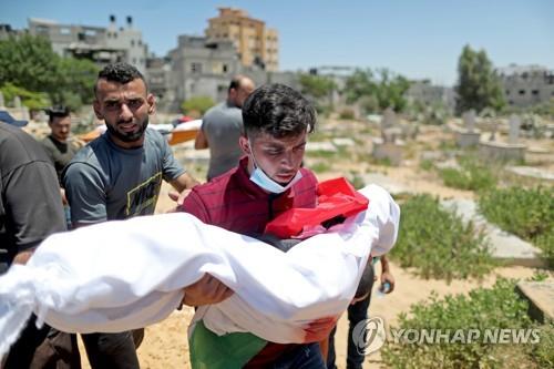 이스라엘 공습으로 숨진 아이의 장례식에서 시신을 안은 팔레스타인 남성