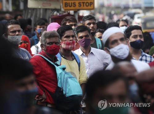 인도 뭄바이에서 마스크를 쓰고 버스를 기다리는 사람들. [AP=연합뉴스]