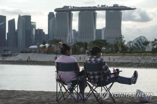 마리나 베이 샌즈 호텔을 보고 앉아있는 싱가포르 시민들.
