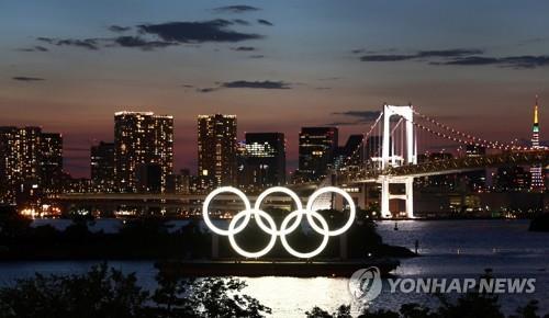 (도쿄 로이터=연합뉴스) 도쿄올림픽 개막을 하루 앞둔 22일 밤 스카이라인을 배경으로 오륜 조형물이 환하게 불을 밝히고 있다. 도쿄올림픽은 23일 개막해 내달 8일 폐막한다. leekm@yna.co.kr